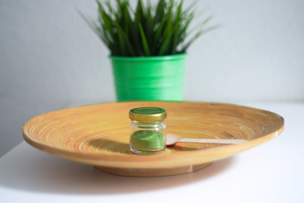 Ein Glas Bio Gerstengras Pulver in einer Bambus Schale